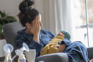 疲惫的新妈妈抱着她的孩子-股票图像