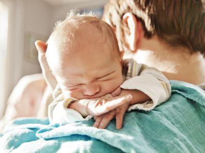 Close-up of father holding his newborn son over the shoulder