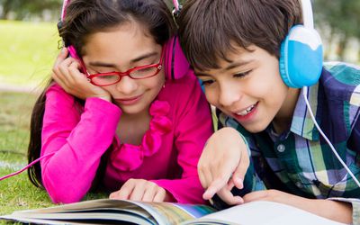 kids with headphones listening to audiobook and reading