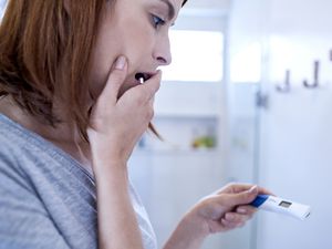 害怕的女人看着验孕棒华体会体育官方人口