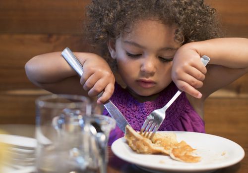 小孩子用银器切食物