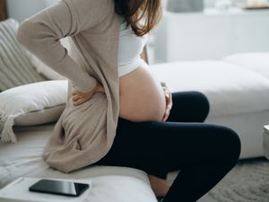 孕妇触摸她的腹部和下背部的短镜头。
