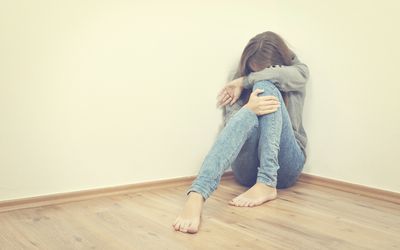 不开心的女孩坐在角落里