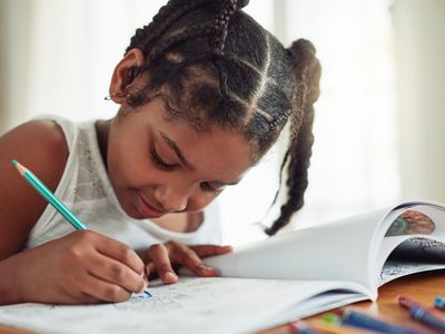 School-aged girl coloring in a coloring book