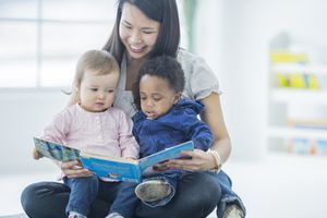 幼儿园老师给两个蹒跚学步的孩子读书