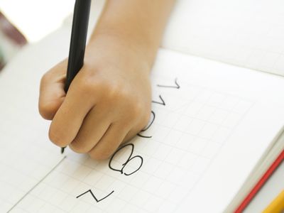 Child's hand writing in notebook