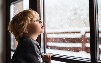 Young boy looking out at the snow