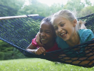 Two best friends laughing on a hammock