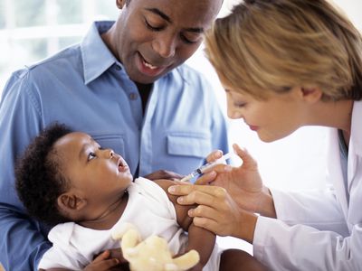 Doctor giving injection to baby boy (2-5 months)