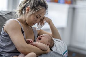 抱着啼哭婴儿的妇女
