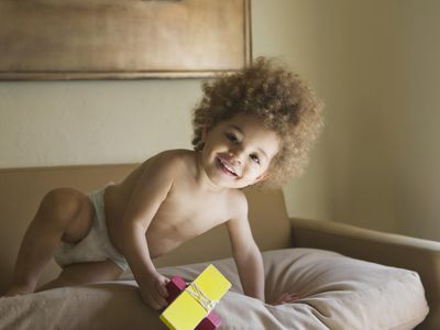 Mixed race boy playing with toy on sofa