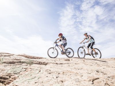 Caucasian mother and son riding mountain bikes