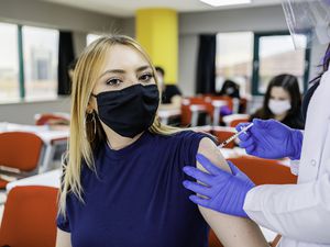 一个小女孩正在从护士那里注射疫苗