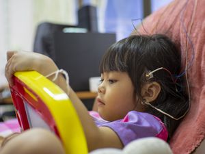 可爱的女孩头部电极放松在椅子上