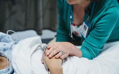医生在病人的病床上让病人感到痛苦