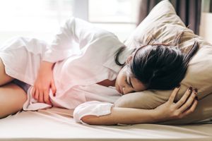 一名妇女在家里的床上睡觉时摸腹部疼痛＂width=