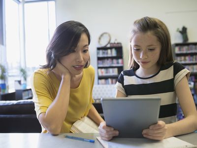 A teacher reads with a student.