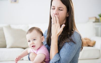 女人抱着婴儿打哈欠