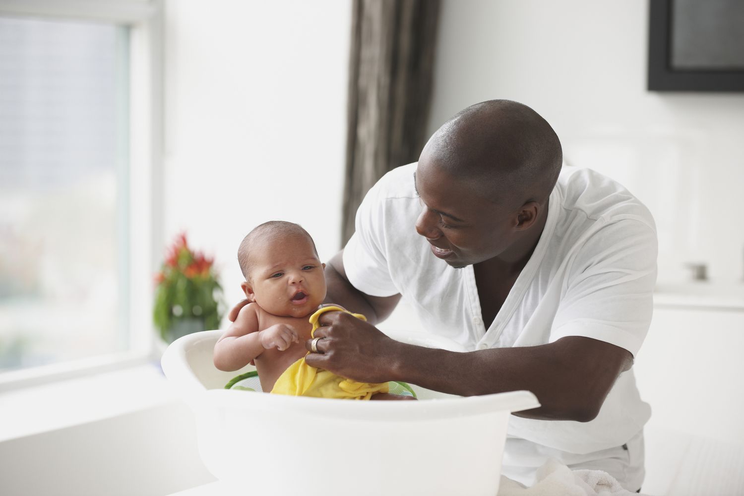 Father bathing infant son