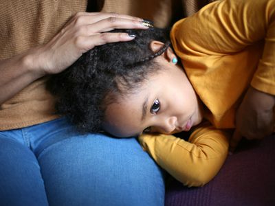 upset girl with head on mother's lap