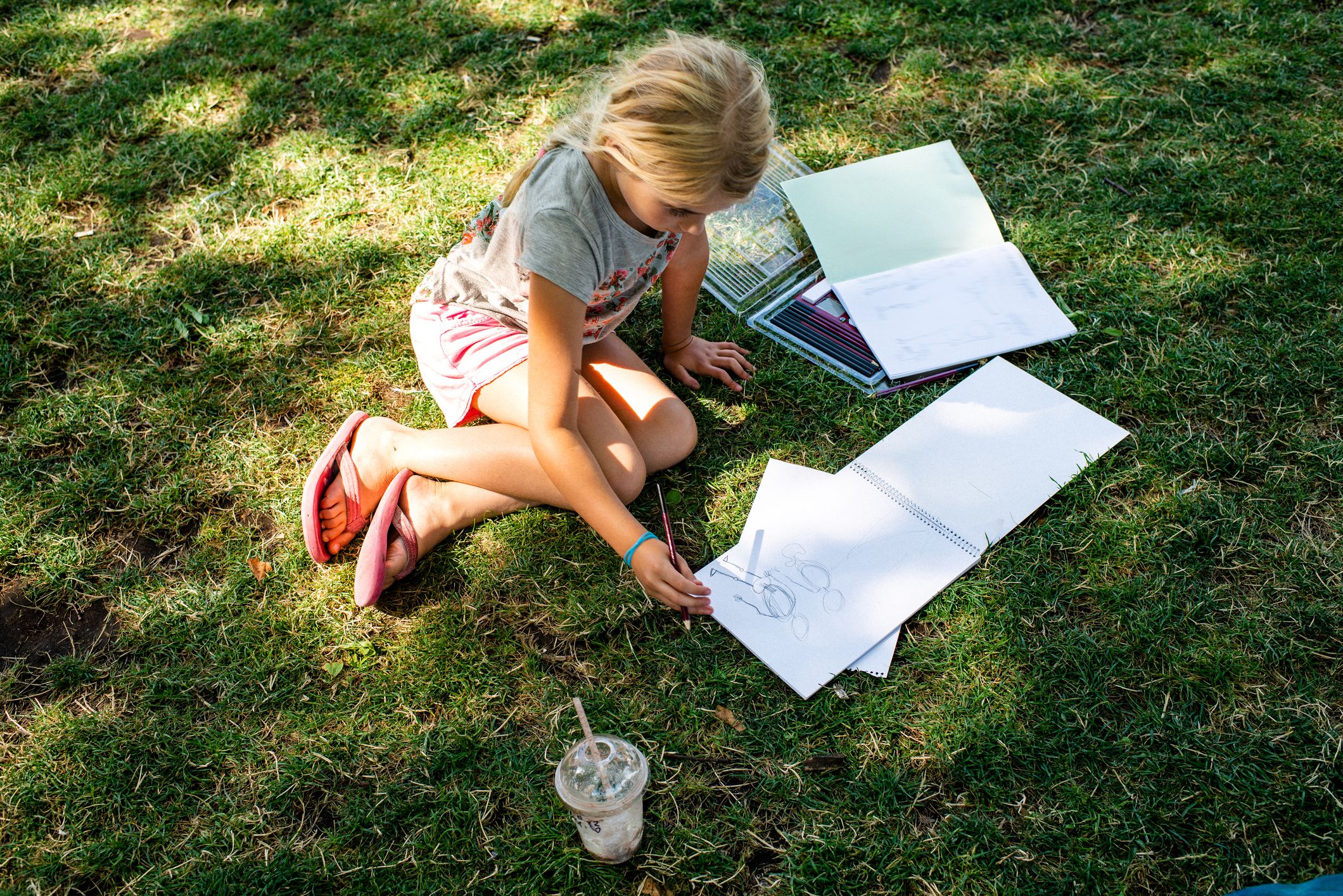 小女孩在草地上做作业