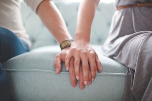 男女手牵手坐在沙发上的照片