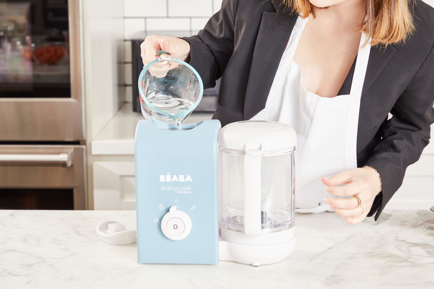 A person pours water into the BÃ©aba Babycook Express.