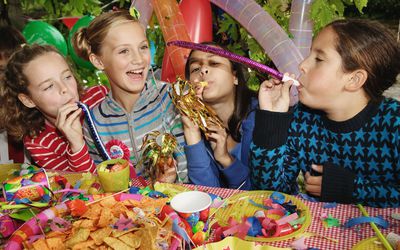 四个孩子(9-11岁)在户外用吹风机参加生日聚会