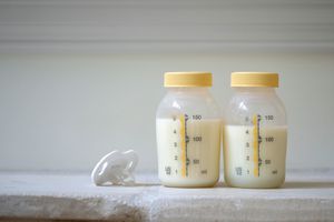 一个奶嘴和两个装满母乳的塑料瓶