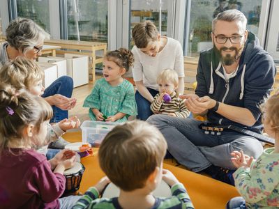 Children and teachers playing and making music in kindergarten