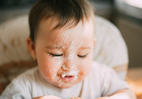 脸上有乳清干酪的婴儿