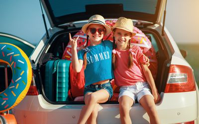 two young girls on the back of a car