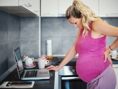 pregnant person holding back