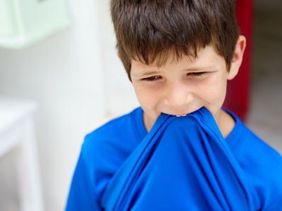 Boy chewing on shirt