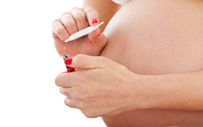 孕妇把大麻放在肚子前面的孕妇