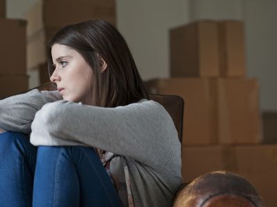 sad teen with moving boxes