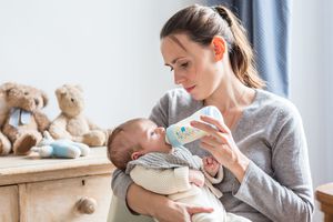 妇女用奶瓶喂婴儿