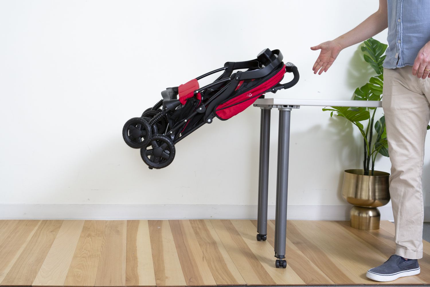Person dropping folded Kolcraft Cloud Plus