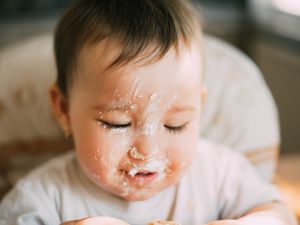 脸上有乳清干酪的婴儿