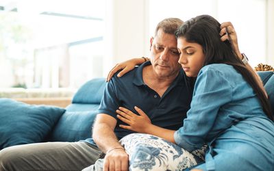 Teenage girl being comforted by a parent