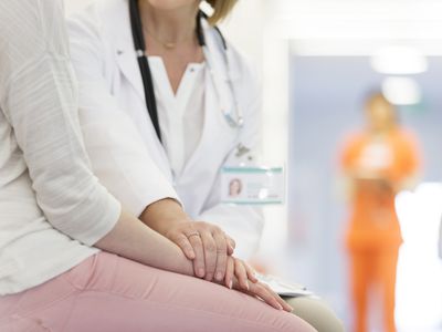 Doctor comforting patient in corridor