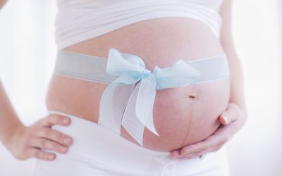 孕妇的肚子，用蓝丝带围起来