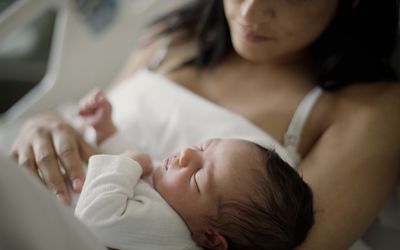 Close up of newborn girl with mom at bed in hospital
