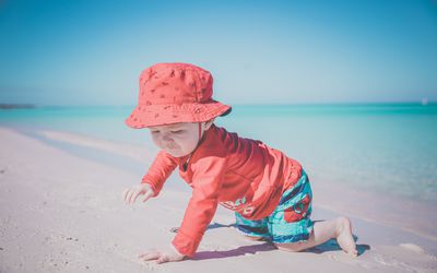 一名男婴在古巴可可岛的热带海滩上爬行