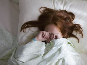 昏昏欲睡的白人女孩躺在床上