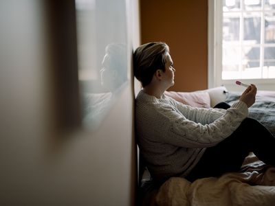 A woman contemplates a pregnancy test result.