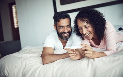 一对微笑的夫妇看着验孕棒华体会体育官方人口