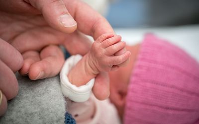 成年人握着新生婴儿的手