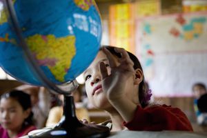 中国，广西，女孩(6-9岁)在课堂上看地球仪