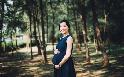妇女穿着裙子抱着怀孕的肚子